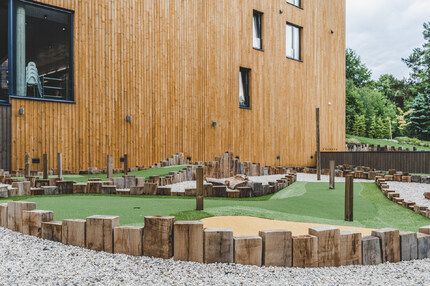 Fasáda hotelu obložena fasádním obkladem KI Trend, v popředí minigolfové hřiště, jehož okraje tvoří zahradní pražce. Fasáda hotelu obložena fasádním obkladem KI Trend, v popředí minigolfové hřiště, jehož okraje tvoří zahradní pražce.